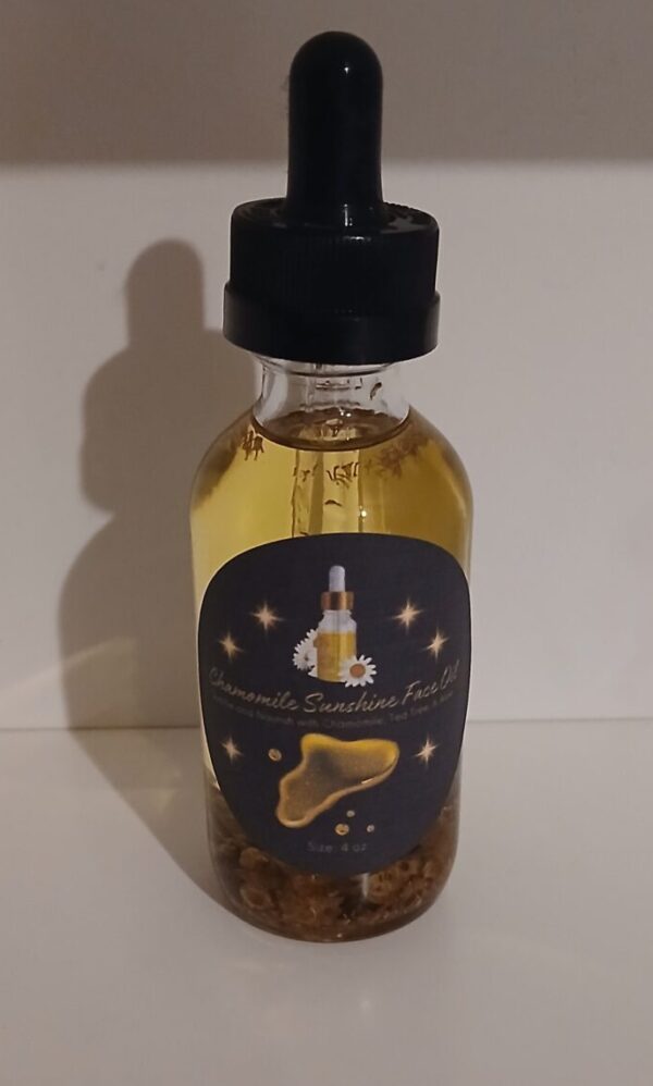 Chamomile Sunshine Face Oil in a glass bottle with chamomile flowers, aloe vera, and tea tree leaves on a wooden surface.