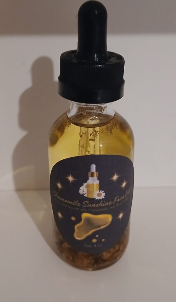 Chamomile Sunshine Face Oil in a glass bottle with chamomile flowers aloe vera and tea tree leaves on a wooden surface