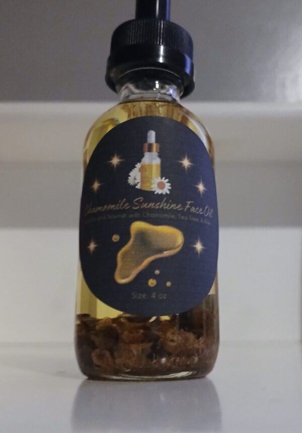 Chamomile Sunshine Face Oil in a glass bottle with chamomile flowers aloe vera and tea tree leaves on a wooden surface